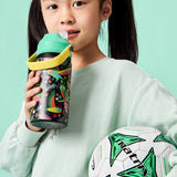 Young girl holding a sports bottle and soccer ball against a teal background